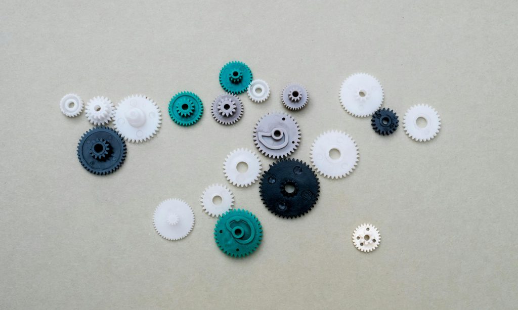 A collection of colorful plastic gears arranged on a plain surface, ideal for mechanical or DIY concepts.